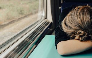 müde Frau schläft im Zug, Credit: Abbie Bernet, Unsplash