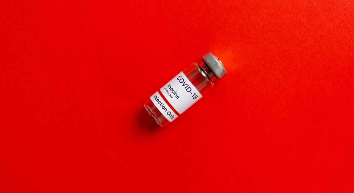 Covid-19-Impfserum auf rotem Hintergrund, Foto: Pexels